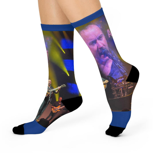 A pair of vibrant concert socks featuring a colorful image of a Dave Matthews Band performance on a blue background, with a visible blue moon and stars design on the ankle area.