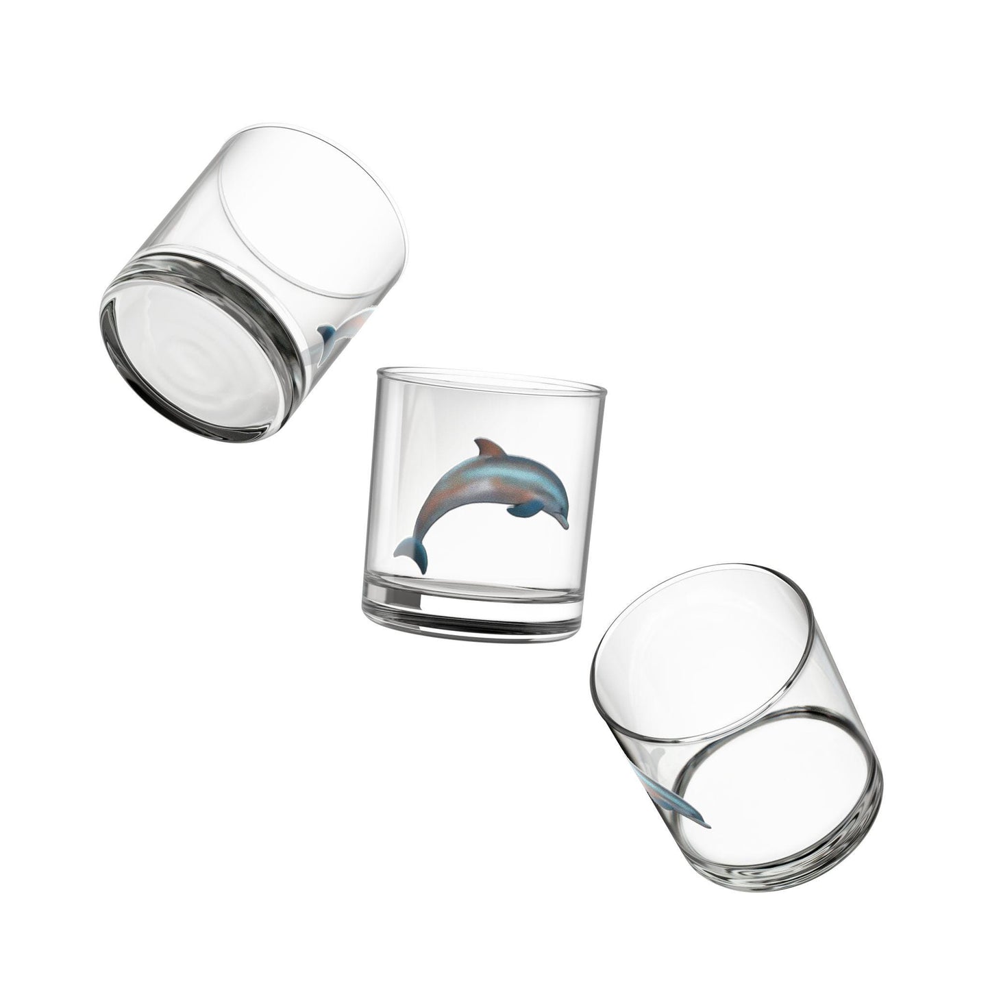 A clear rocks glass with a hand-drawn dolphin design on it.