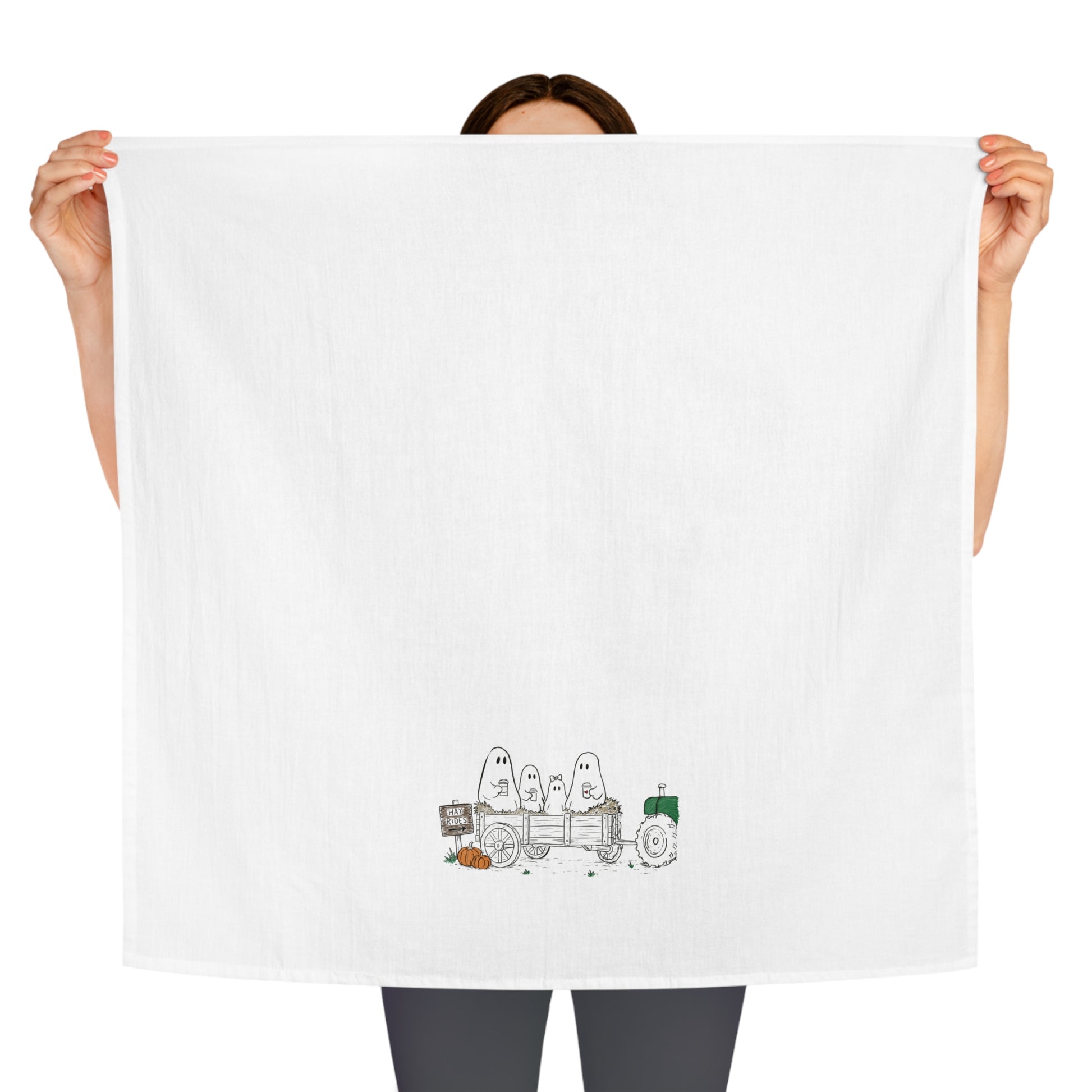 Hand-drawn ghost family riding on a fall hayride with pumpkins on a farmhouse tea towel.