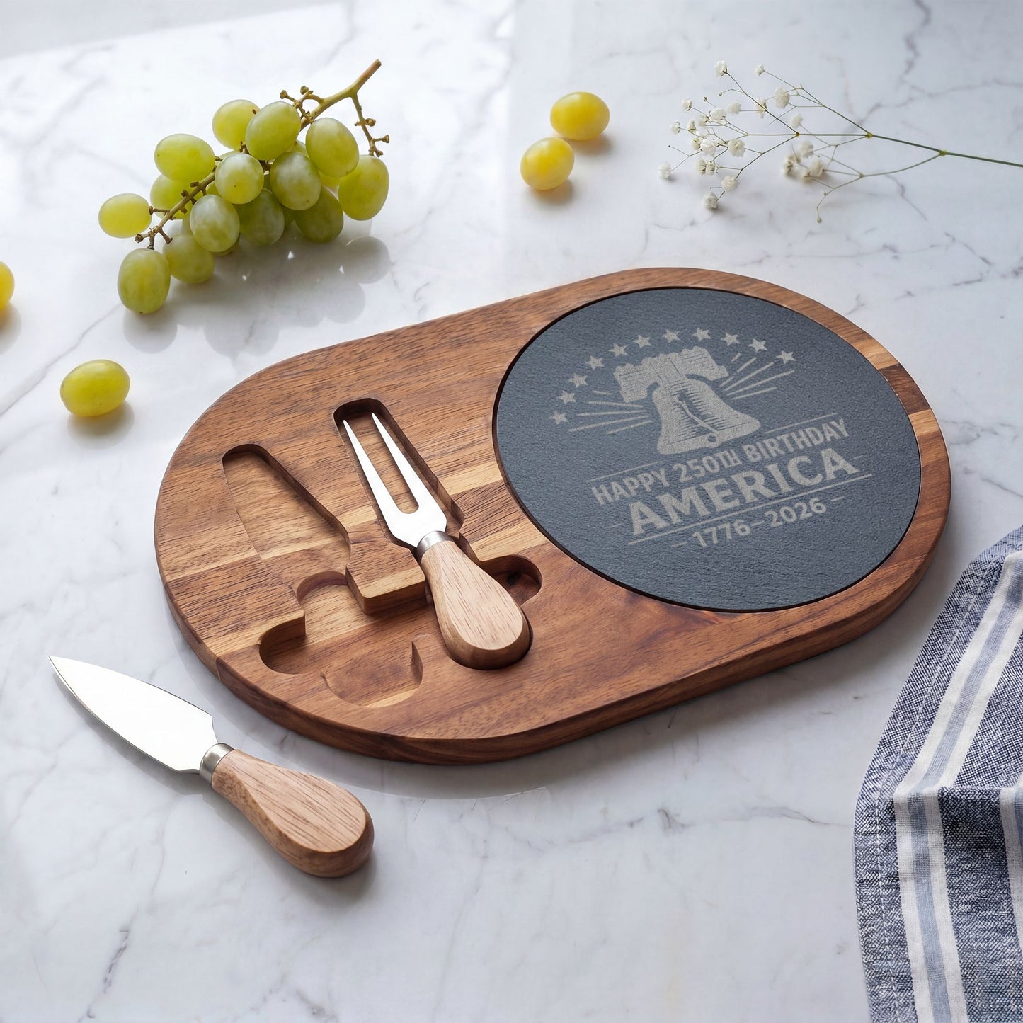 Wooden cheese board set with engraved design on a marble surface with grapes and a knife.