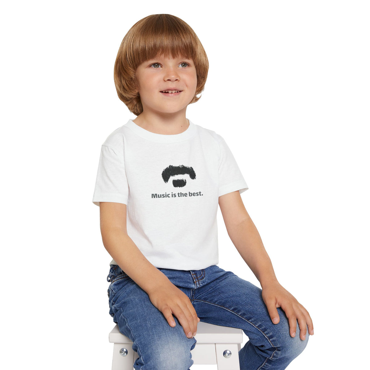 Child wearing a white t-shirt with 'music is the best’ on a white background