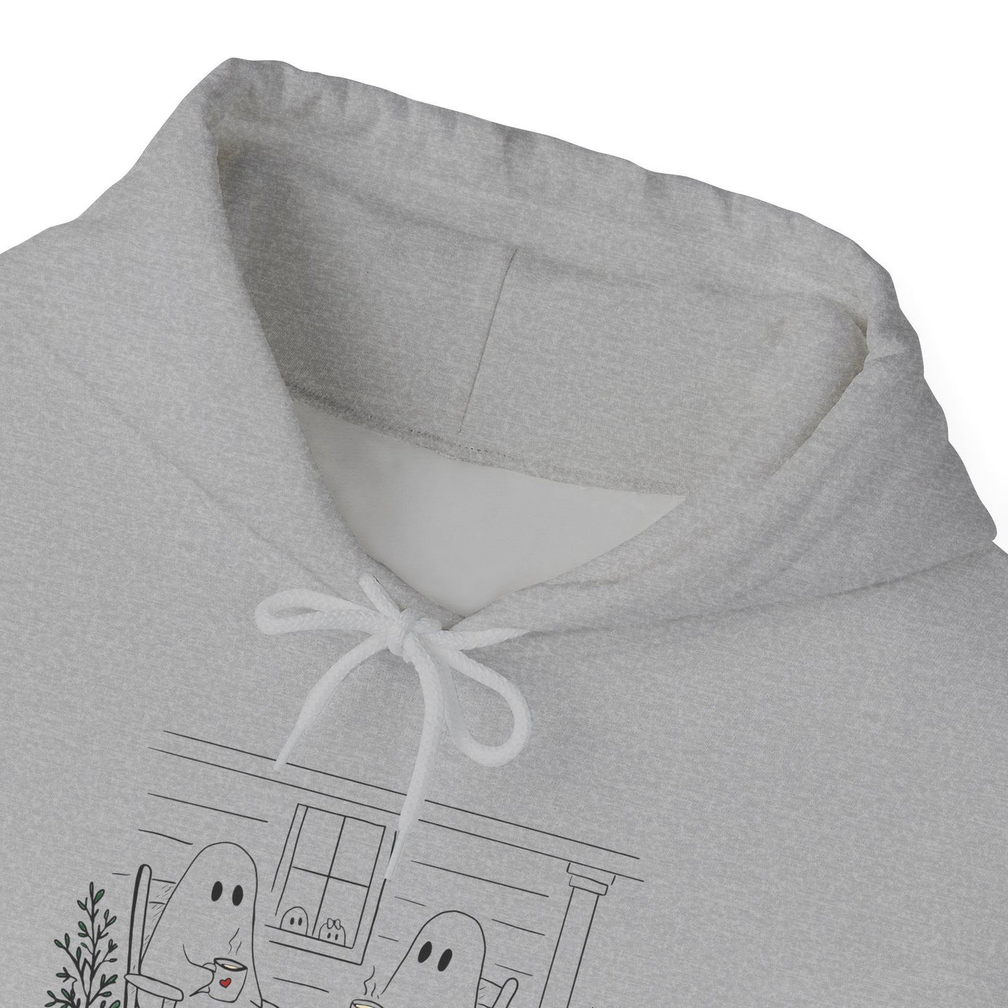 Pullover hoodie featuring a hand-drawn ghost family enjoying coffee in rocking chairs on a front porch, with two little ghosts peeking through the window, a pumpkin, and subtle fall color accents.