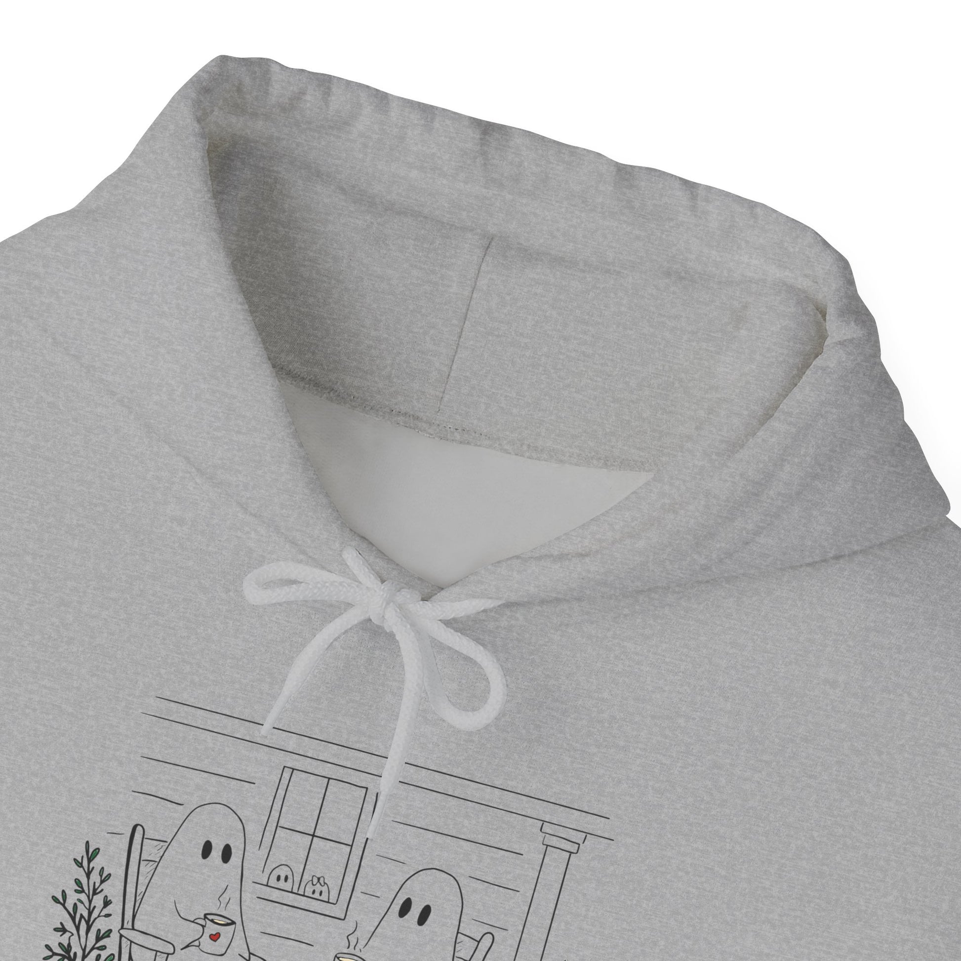 Pullover hoodie featuring a hand-drawn ghost family enjoying coffee in rocking chairs on a front porch, with two little ghosts peeking through the window, a pumpkin, and subtle fall color accents.