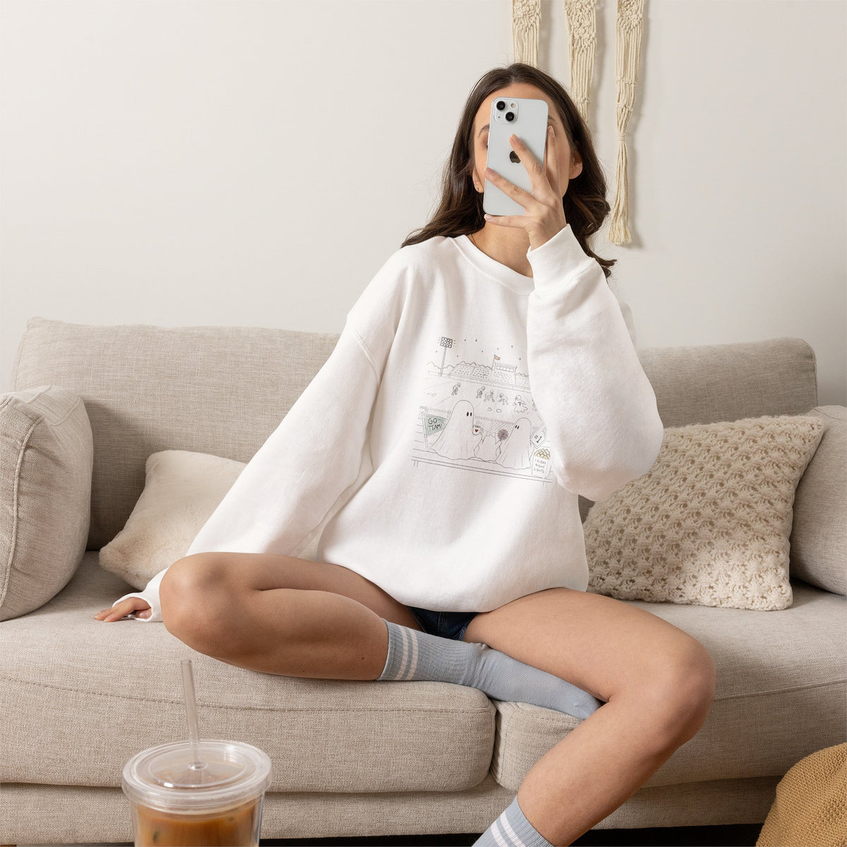 White crewneck sweatshirt featuring original cute ghost family football artwork from Friday Night Lights, Chapter 5 of The Story of the Ghost by Market Mafia Creations.