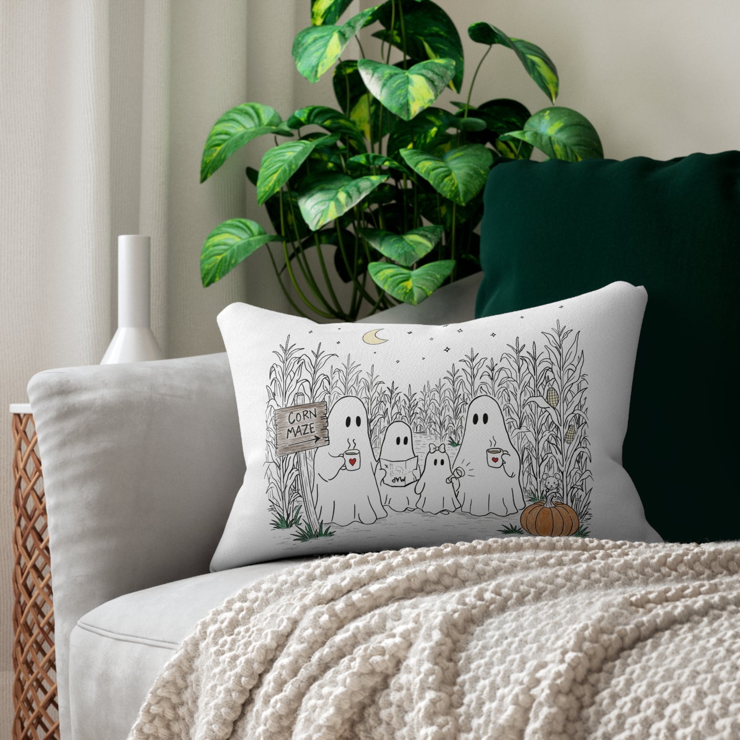 Rectangular lumbar pillow featuring a hand-drawn ghost family walking through a moonlit corn maze with warm drinks, tall corn stalks, and a pumpkin from The Story of the Ghost Chapter 2 collection.