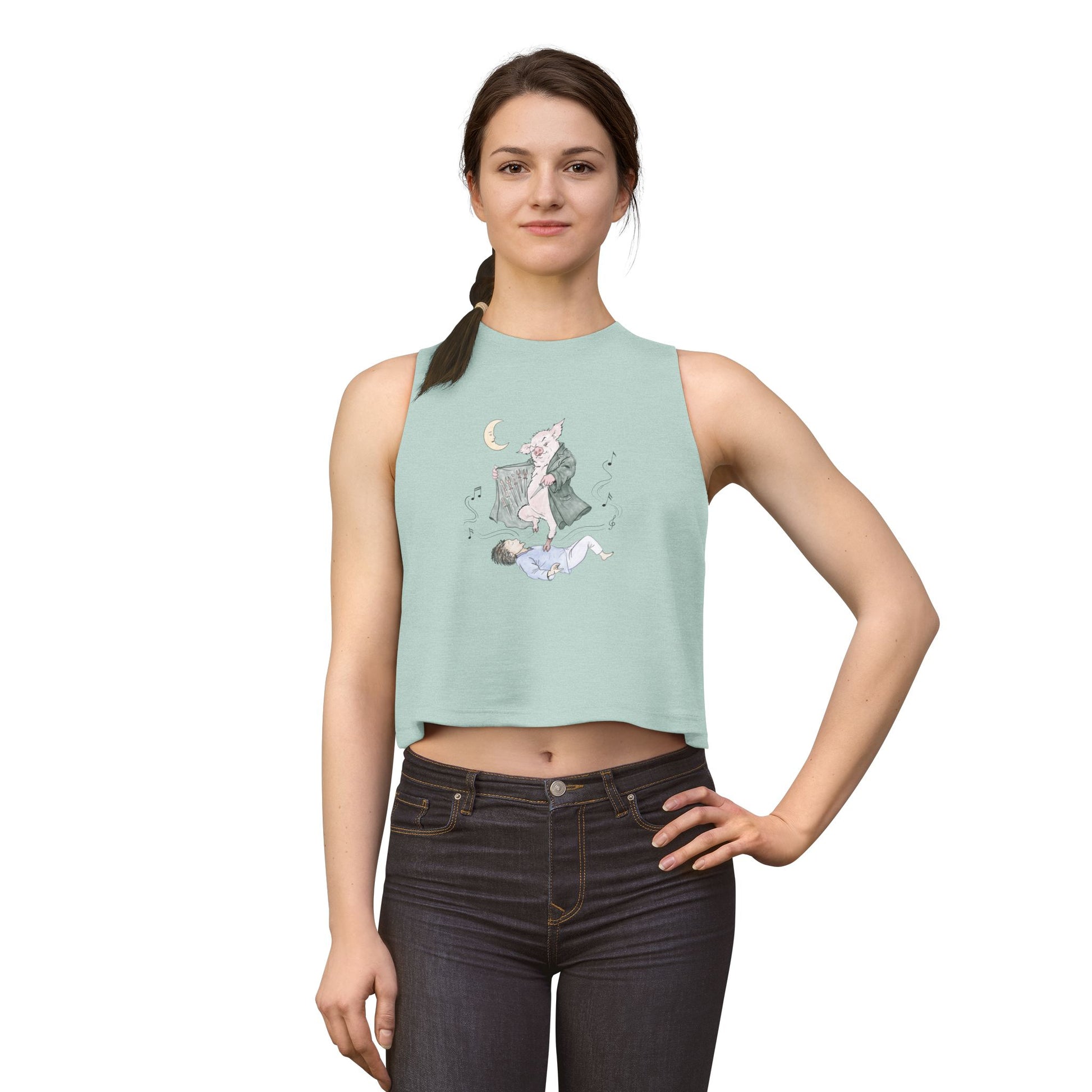 Woman’s cropped tank top featuring original hand-drawn Guyute-inspired artwork with a surreal pig, moon, musical mist, and muted storybook colors.