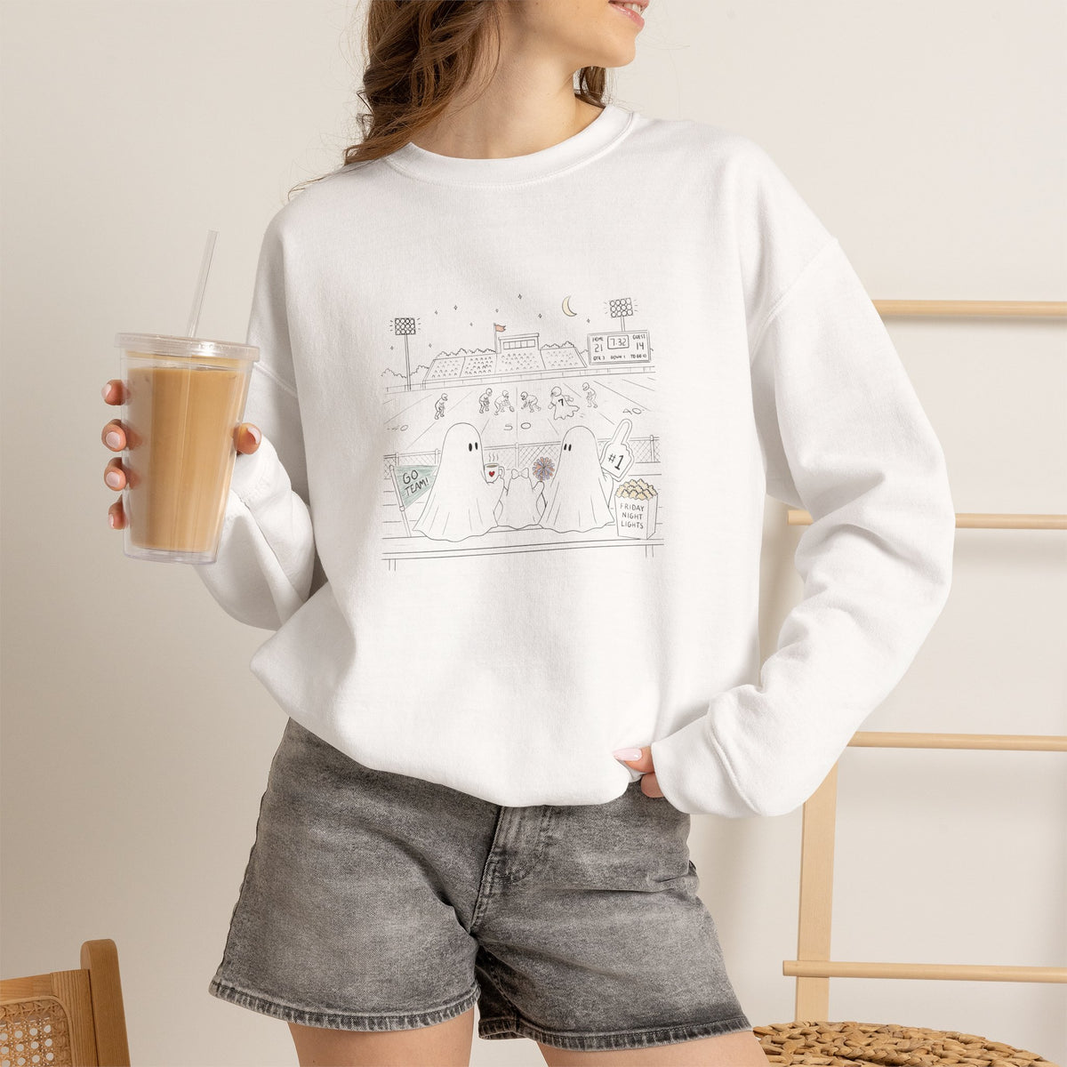 White crewneck sweatshirt featuring original cute ghost family football artwork from Friday Night Lights, Chapter 5 of The Story of the Ghost by Market Mafia Creations.