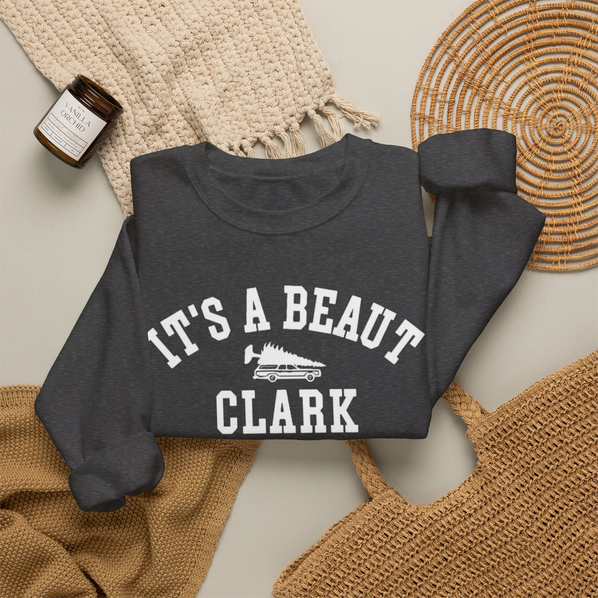 Dark heather crewneck sweatshirt featuring white It’s a Beaut Clark lettering and a station wagon carrying a Christmas tree.