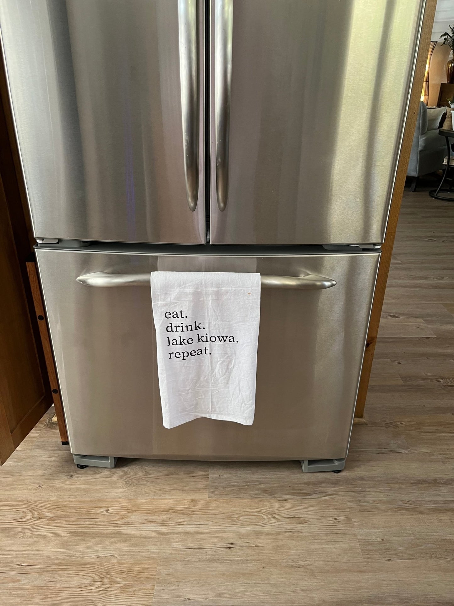 Stainless steel refrigerator with a paper towel on the door handle.