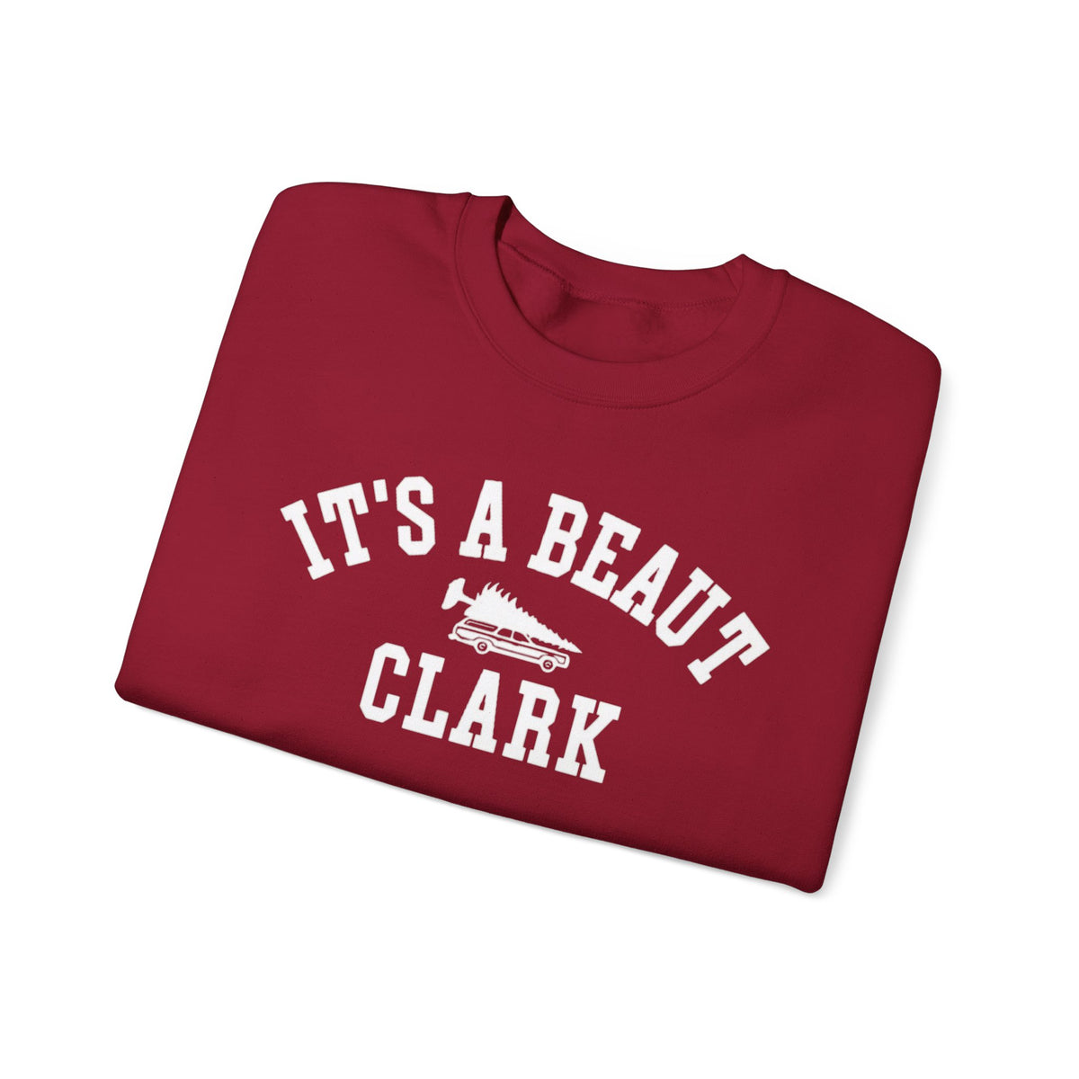 Cardinal red crewneck sweatshirt featuring white It’s a Beaut Clark lettering and a station wagon carrying a Christmas tree.