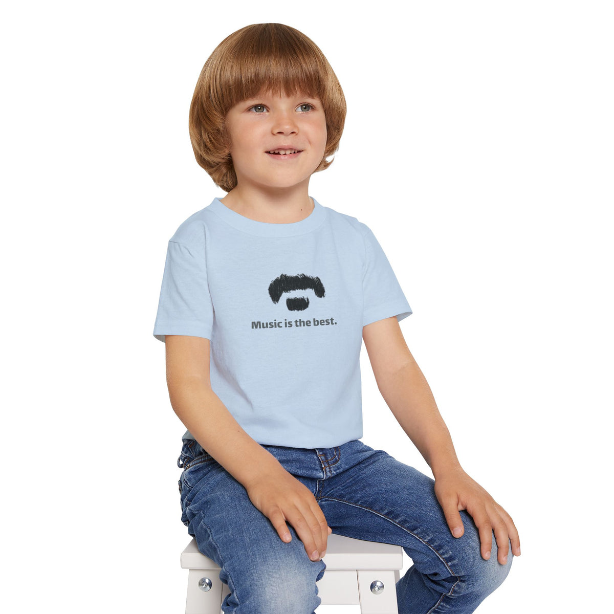 Child wearing a light blue t-shirt with 'music is the best' text on a white background