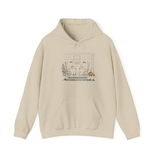 Pullover hoodie featuring a hand-drawn ghost family enjoying coffee in rocking chairs on a front porch, with two little ghosts peeking through the window, a pumpkin, and subtle fall color accents.