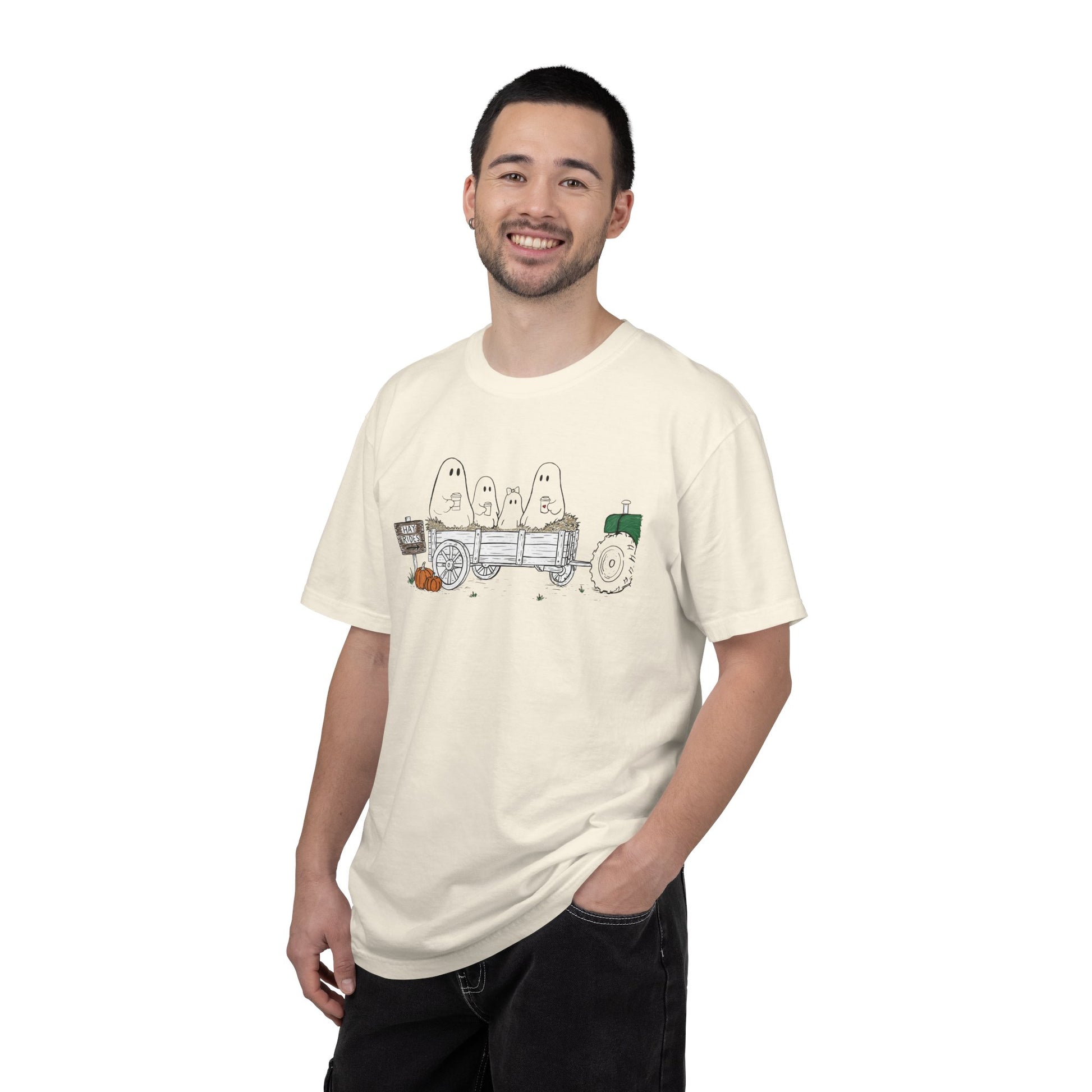 Comfort Colors ivory t-shirt featuring a hand-drawn ghost family riding in a hay wagon with pumpkins, coffee mugs, and a vintage tractor from The Story of the Ghost Chapter 1 collection.