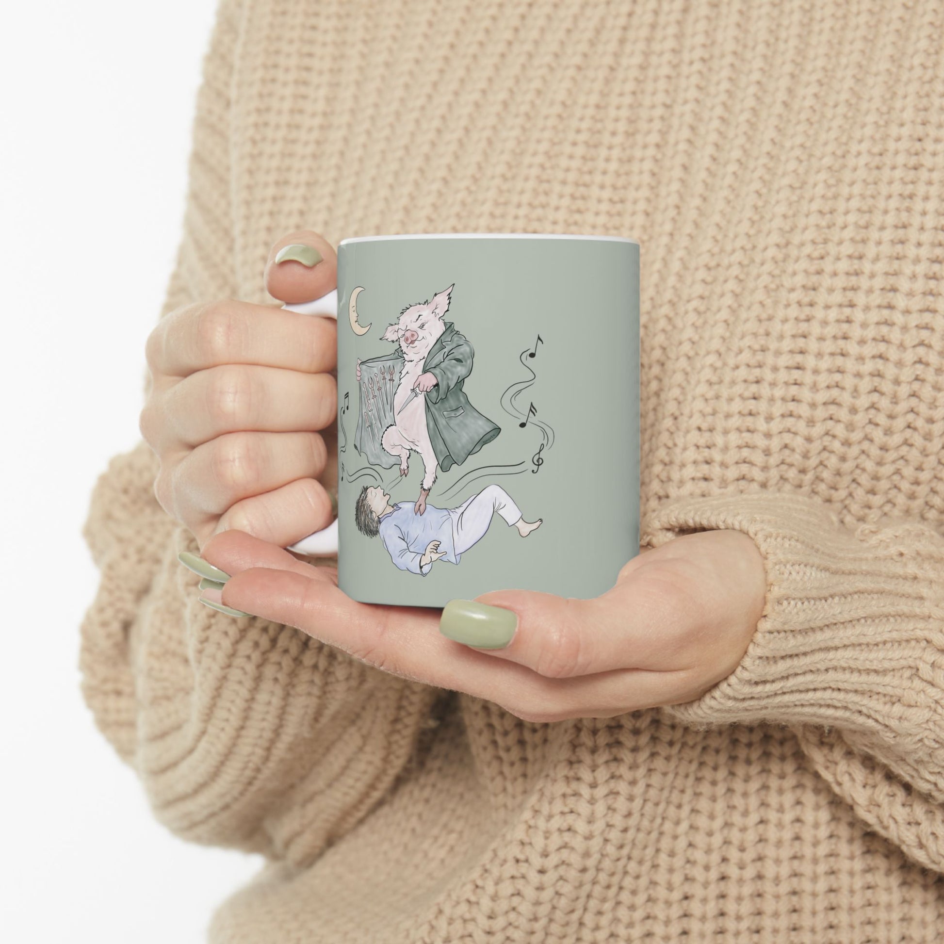 Sage green ceramic mug featuring original hand-drawn Guyute-inspired artwork with a surreal pig, musical mist, moon, and hidden song details.