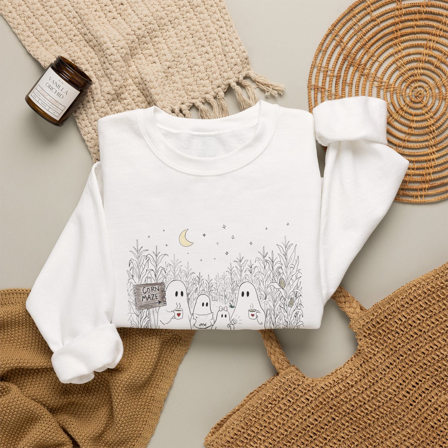 Crewneck sweatshirt featuring a hand-drawn ghost family walking through a moonlit corn maze with warm drinks, tall corn stalks, and a pumpkin from The Story of the Ghost Chapter 2 collection.