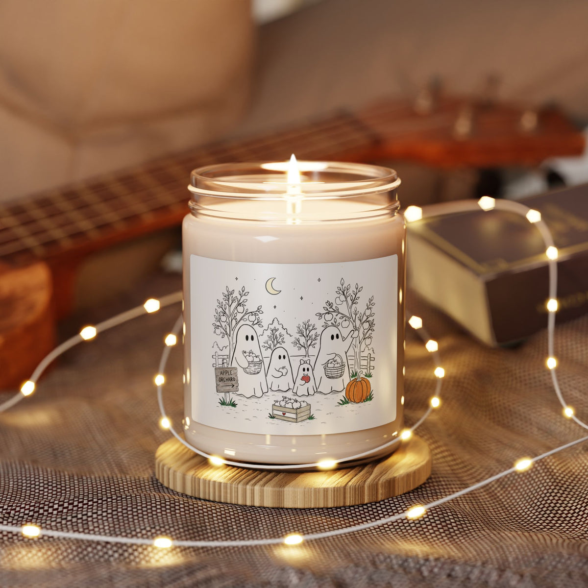 Apple Harvest soy candle featuring the ghost family picking apples in the Apple Orchard artwork from Chapter 4 of The Story of the Ghost.