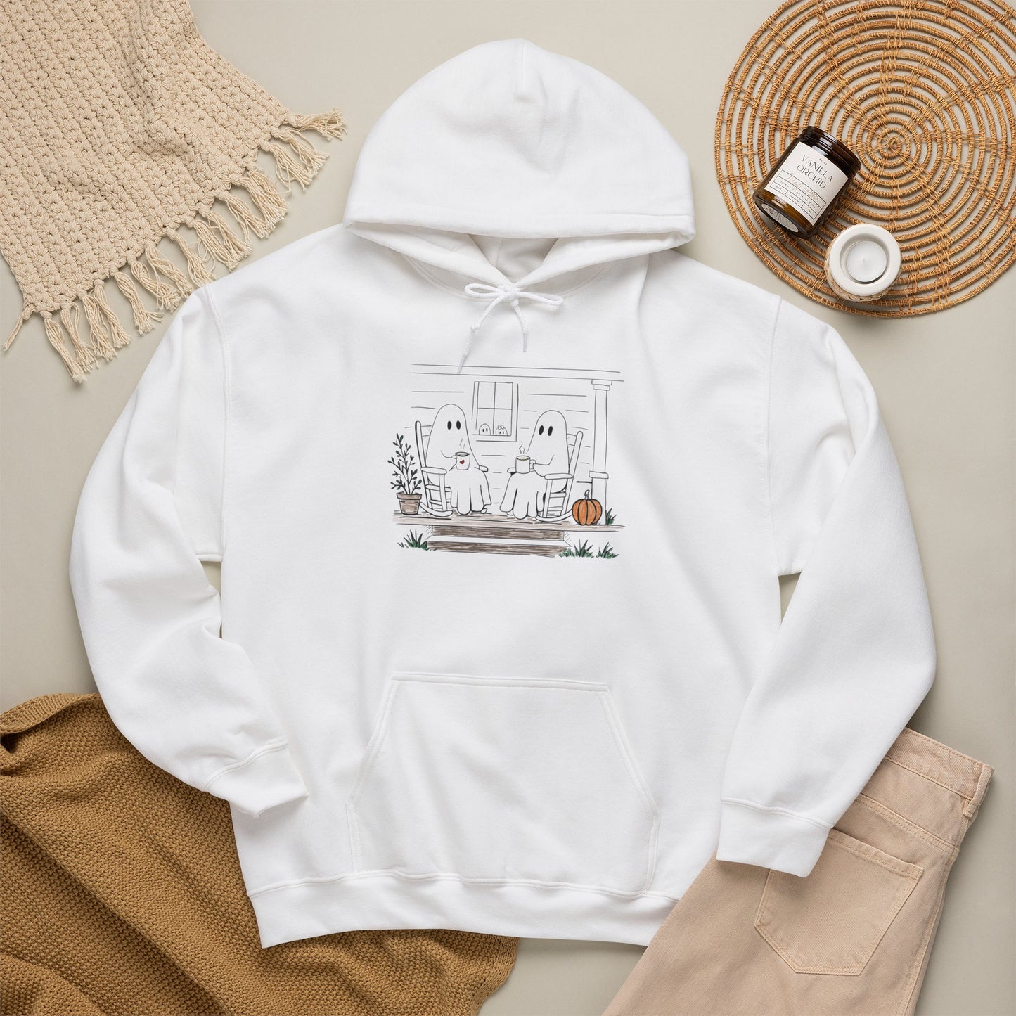 Pullover hoodie featuring a hand-drawn ghost family enjoying coffee in rocking chairs on a front porch, with two little ghosts peeking through the window, a pumpkin, and subtle fall color accents.
