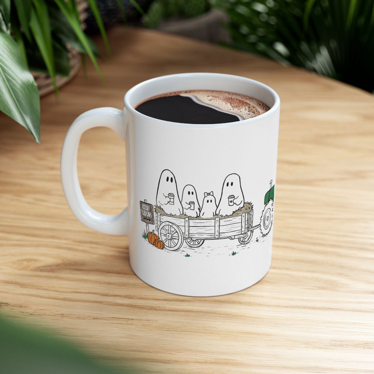Ghost family riding in a hay wagon with pumpkins and coffee mugs, featured on a white ceramic coffee mug from The Story of the Ghost Chapter One: Hayrides fall collection by Market Mafia Creations.