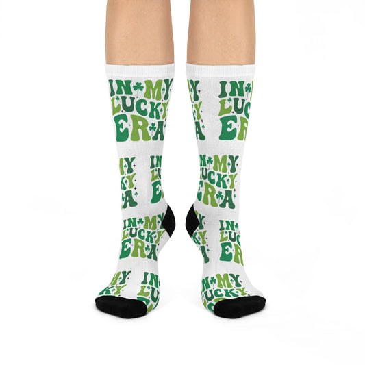 A pair of white crew socks with green text pattern that reads 'IN MY LUCKY SOX', suitable for St. Patrick's Day celebrations.